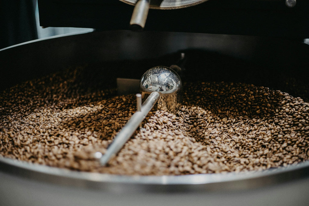 A coffee roaster working at the roastery in warm light